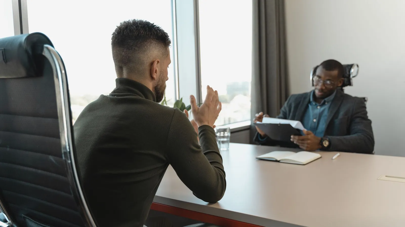 Zwei Männer in einem Gespräch an einem Besprechungstisch